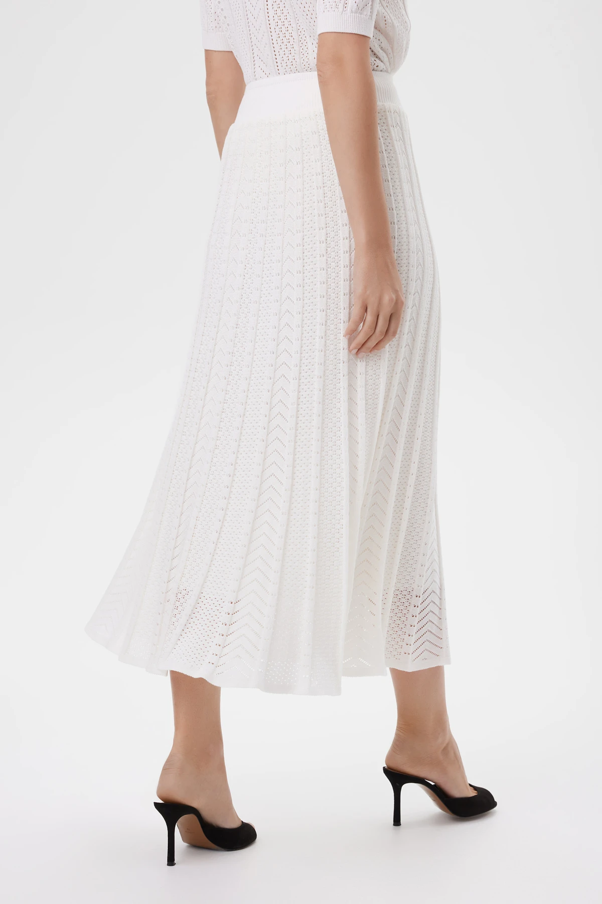 Боковой ракурс юбки, показывающий плавное движение и мягкий объем.